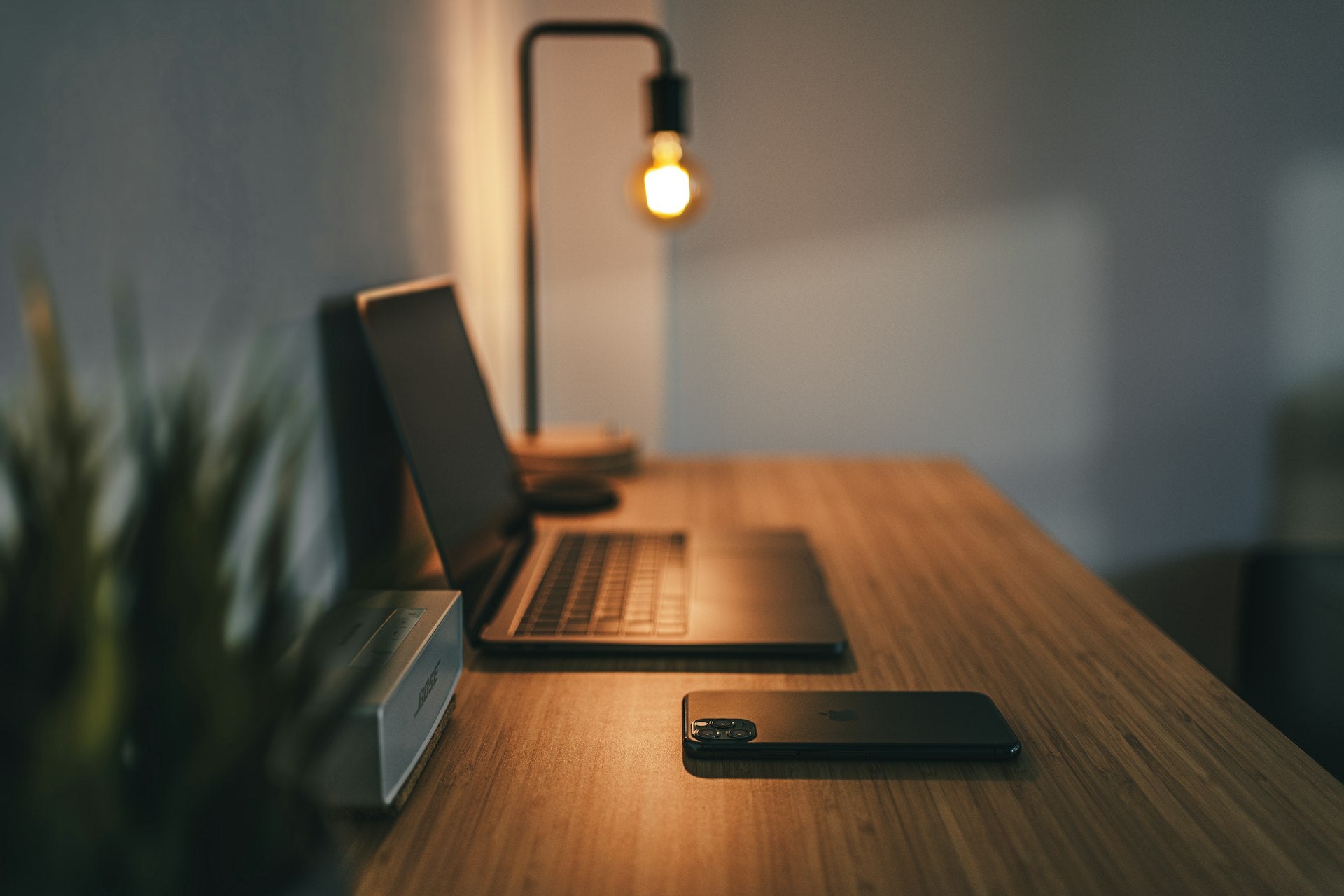 Tidy desk with laptop and warm lamp in the evening